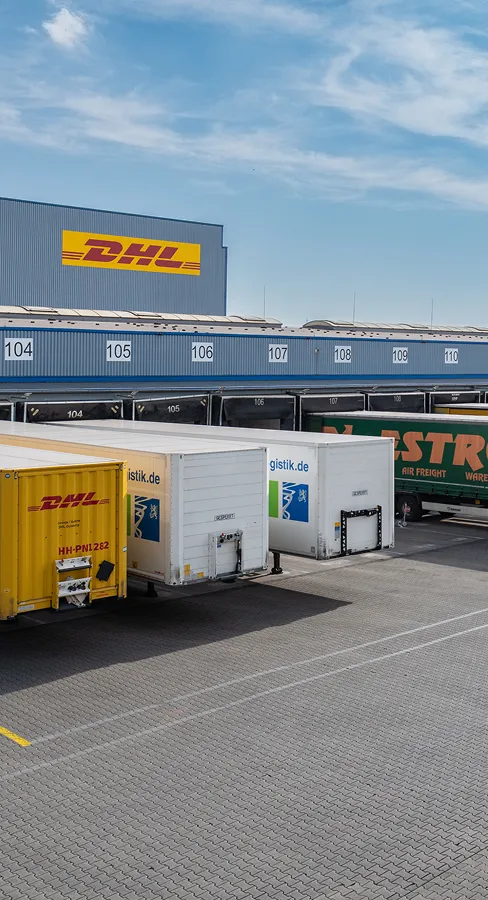 DHL and gistik.de trailers docked at numbered loading bays of a logistics hub