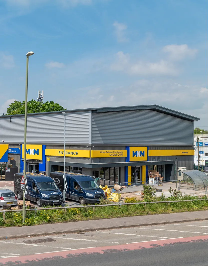 MKM building and landscaping showroom with branded vans parked outside a retail warehouse